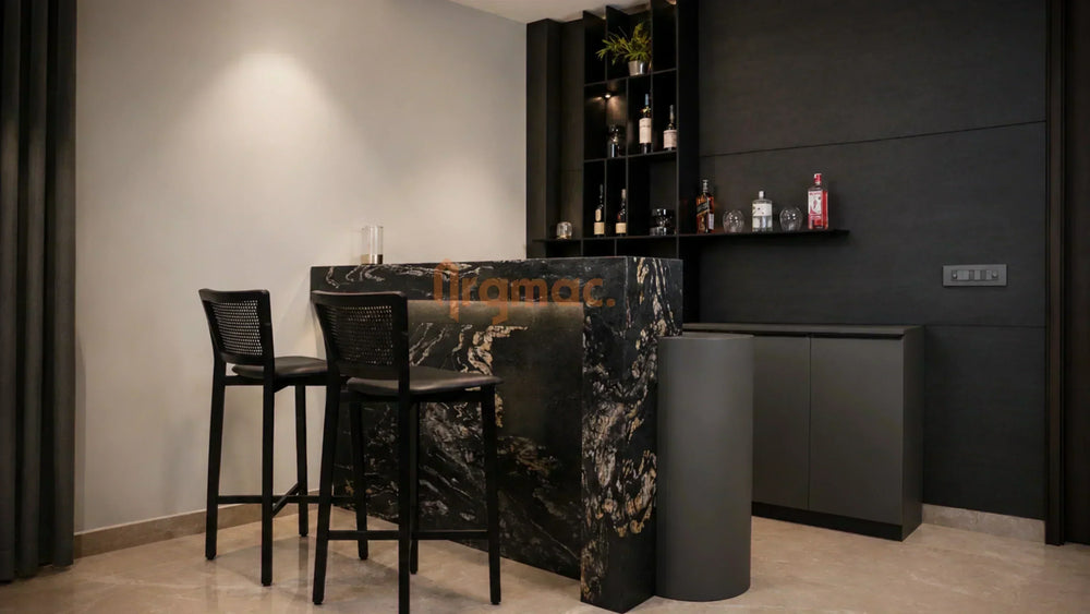 ARGMAC home bar counter in black and gold marble, backlit shelving stocked with bottles and glassware, two cane-back bar stools set on marble flooring inside a moody dark interior.