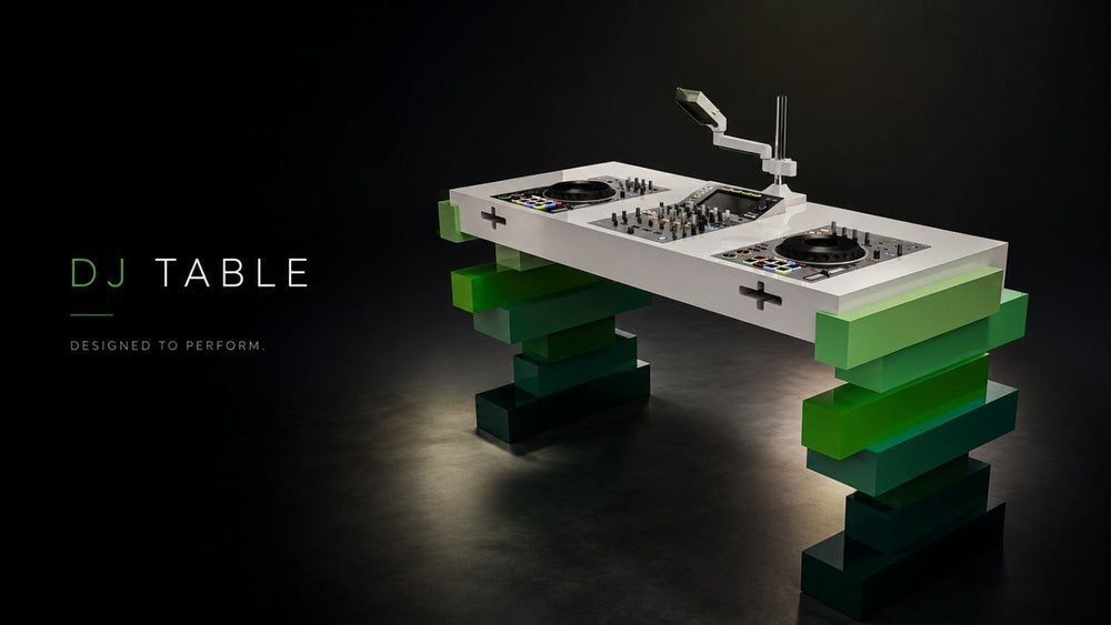 ARGMAC Aerixa DJ table top in glossy white with turntables, a mixer and a monitor arm, on a sculptural stacked green geometric wood base, against a dark and reflective studio floor.