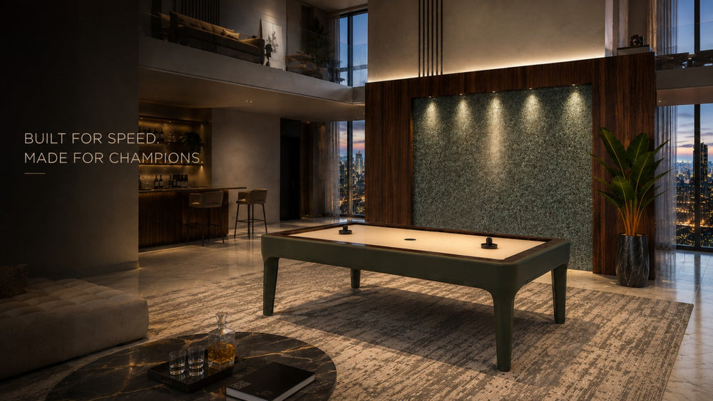 ARGMAC Negroni air hockey table with an olive green frame, ivory surface, and air hockey pucks, blog cover in a loft with skyline views, a stone wall, wood paneling, and a home bar.